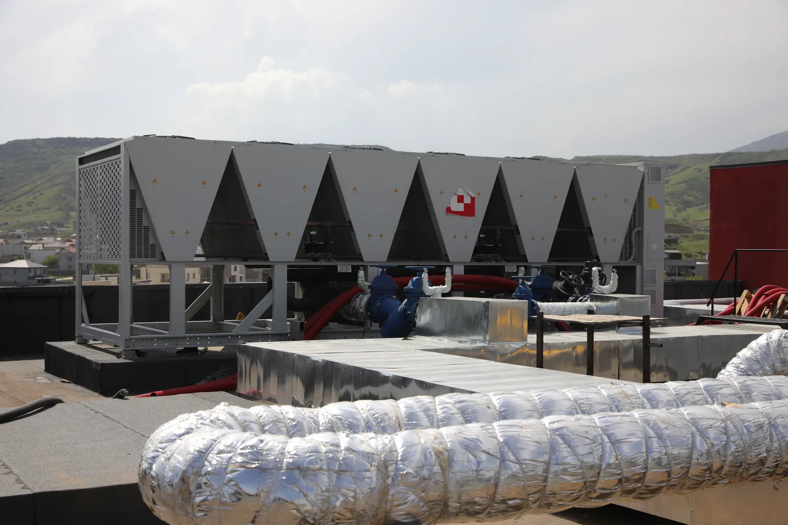 Rooftop galvanised ductwork with Tbilisi skyline
